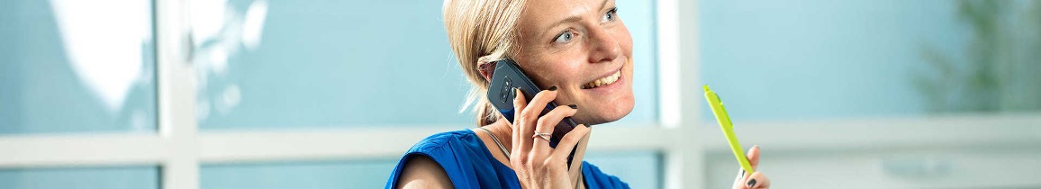 Medarbejder i samtale via virksomhedens omstillingsbord på mobiltelefon