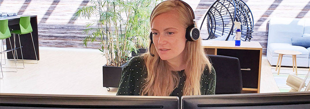 Kundeservicemedarbejder med headset foran skærme som illustration af CRM og telefoni integration hvordan virker det?