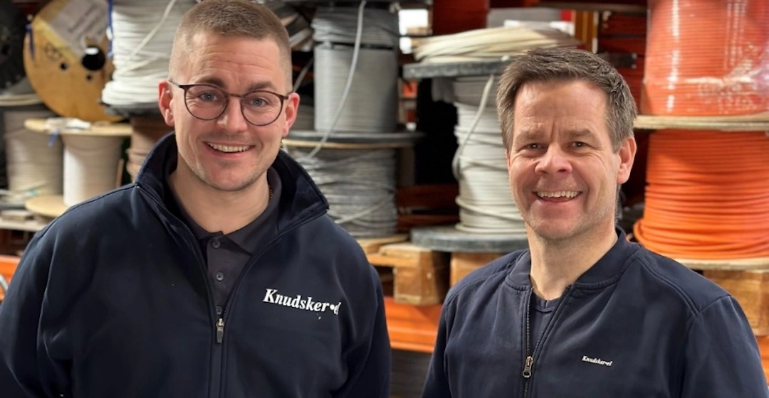 To kolleger i arbejdsjakker i lager med anbefalinger til mobilabonnementer for tømrere